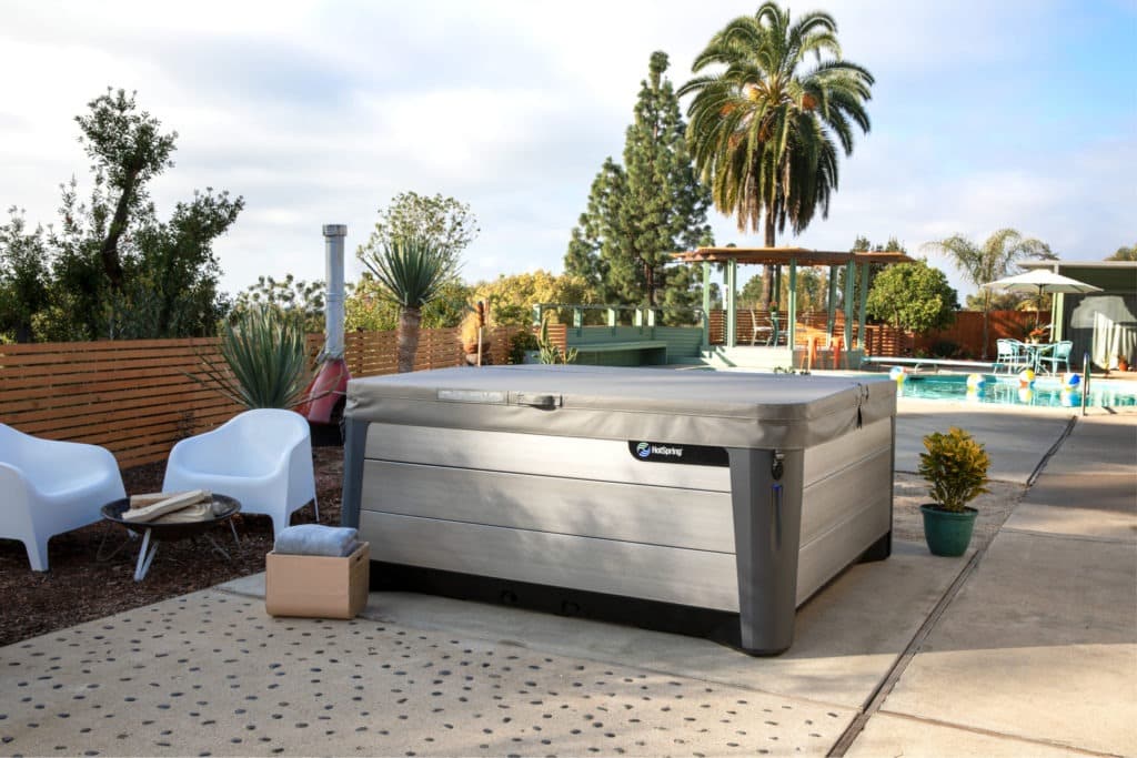 A HotSpring® hot tub installation in the backyard with a cover.